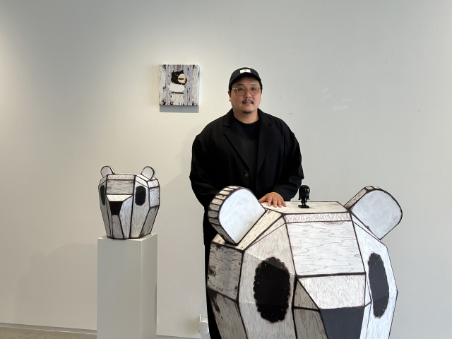 갤러리 우 전시장에서 만난 한충석 작가. 한 작가의 작품 '마스크' 시리즈를 마분지로 만든 조형물 앞에서 포즈를 취했다. 김은영 기자 key66@