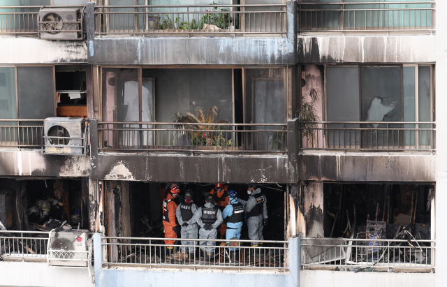 18일 서울 마포구 창전동 아파트 화재 현장에서 경찰과 소방 관계자들이 합동감식을 하고 있다. 연합뉴스