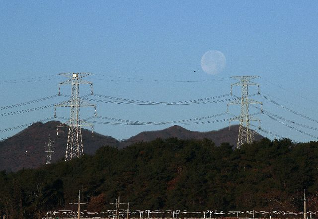 수도권까지 전기를 보내기 위해 전국 산야에 설치된 거대 송전탑만 4만 개가 넘는 것으로 알려져 있다. 울산 울주군 송전탑 뒤로 슈퍼문이 지고 있다. 부산일보DB