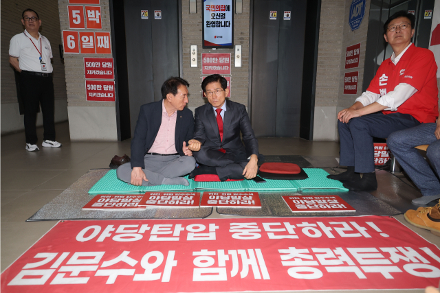 김건희 특검의 국민의힘 당사 압수수색에 반대하며 당사 현관에서 농성 중인 김문수 당 대표 후보가 18일 김석기 의원과 대화를 하고 있다. 연합뉴스