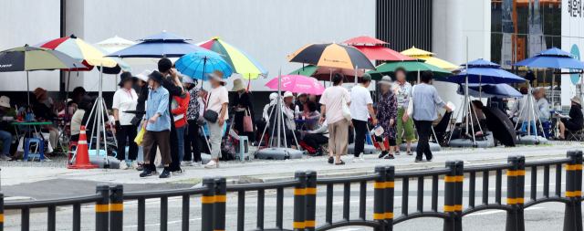 하반기 부산 신축 단지들의 분양이 잇따르면서 이들의 성적에 관심이 집중된다. 지난달 ‘르엘 리버파크 센텀’ 견본주택 인근에 이른바 ‘떴다방’이 등장해 방문객들과 상담을 하고 있다. 정종회 기자 jjh@