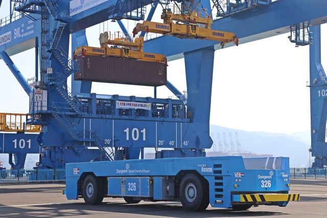 지난 7월 3일 부산항국제전시컨벤션센터에서 열린 ‘2025 스마트항만 기술산업 국제포럼’ 참가자들이 화이팅을 외치고 있다(위). 완전자동화부두인 부산항 신항7부두에서 자동이송장치(AGV)가 스스로 움직이고 있다. KMI·BPA 제공