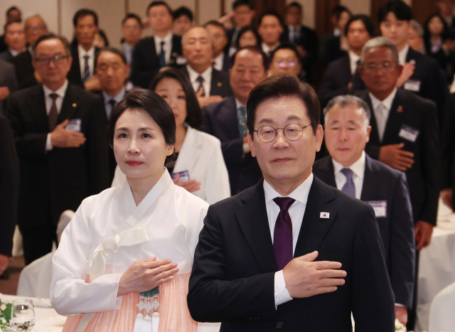 이재명 대통령과 김혜경 여사가 23일 일본 도쿄의 한 호텔에서 열린 재일동포 오찬 간담회에서 국기에 경례하고 있다. 연합뉴스