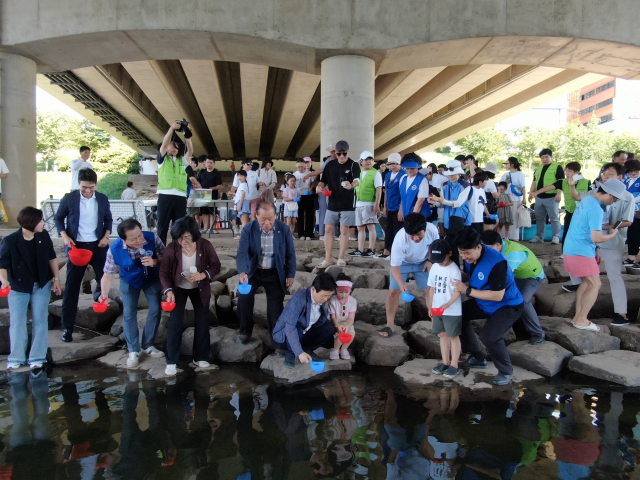 ‘제3회 쏘가리 방류 행사’가 24일 진주시 충무공동 소재 에나교 아래에서 펼쳐졌다. 한국자유총연맹 진주시지회 충무공동위원회 제공