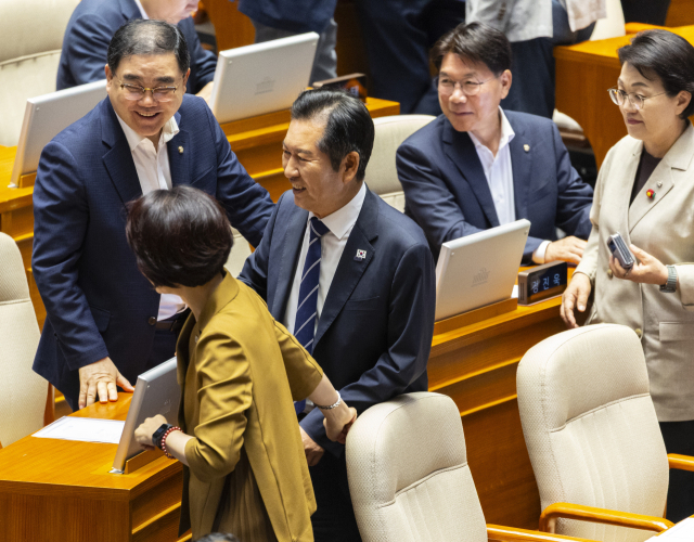 더불어민주당 정청래 대표가 25일 국회에서 열린 본회의 도중 열린 상법개정안 무제한토론 중단을 위한 투표를 마친 뒤 당 소속 의원들과 대화하고 있다. 연합뉴스