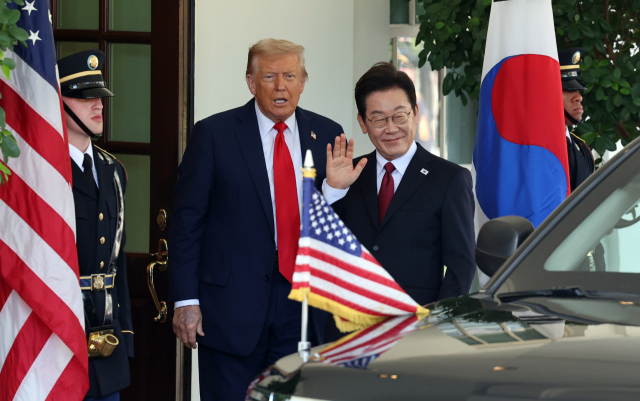 이재명 대통령이 25일(현지시간) 미국 워싱턴DC 백악관에서 영접나온 도널드 트럼프 미국 대통령과 기자들을 바라보며 손을 흔들고 있다. 연합뉴스