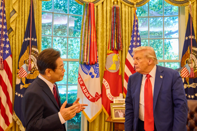 이재명 대통령이 25일(현지 시간) 미국 워싱턴DC 백악관 오벌오피스에서 열린 한미 정상회담뒤 도널드 트럼프 미국 대통령과 대화하고 있다. 연합뉴스