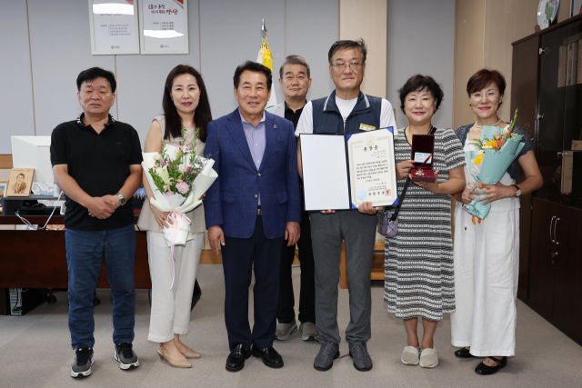 나동연 양산시장이 6·25 전쟁에 참전해 공을 세운 고 박인남 씨 자녀에게 화랑무공훈장 등을 전수한 뒤 기념사진을 찍고 있다. 양산시 제공