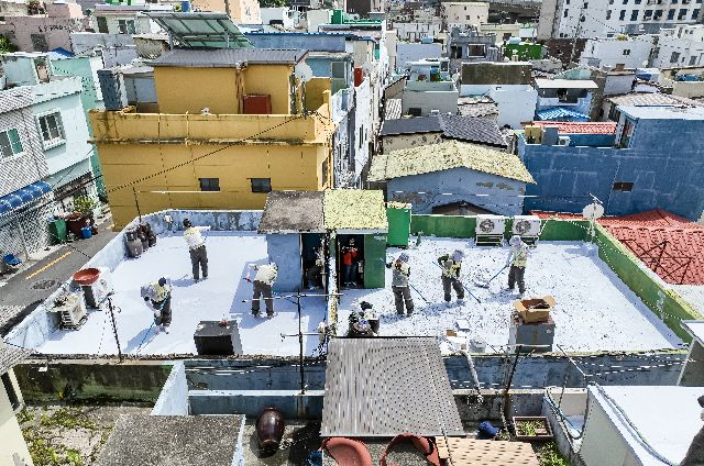 부산 남구 전포대로 일원에서 쿨루프(Cool Roof) 봉사에 나선 자원봉사자들이 폭염 취약가구 20여 곳 대상으로 친환경 열차단 페인트를 칠하고 있다. 김종진 기자 kjj1761@
