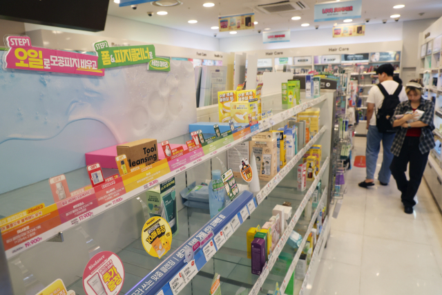 지난 7월 27일 '민생회복 소비쿠폰' 사용 가능 매장인 서울 시내 한 올리브영 가맹점 진열대가 대부분 동나고 텅 비어 있다. 연합뉴스
