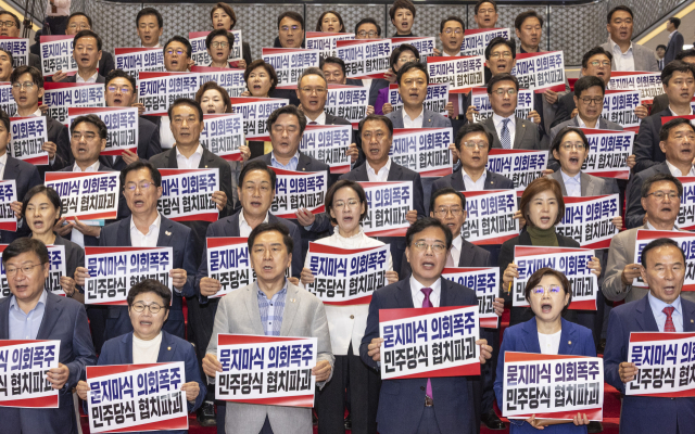 국민의힘 송언석 원내대표를 비롯한 의원들이 27일 국회 본청 계단에서 열린 '묻지마식 의회폭주 민주당식 협치파괴' 규탄대회에서 손팻말을 들고 구호를 외치고 있다. 국민의힘은 이날 본회의에서 당이 추천한 인권위원 2명에 대한 선출이 표결을 통해 부결된 뒤, 이에 반발해 퇴장한 뒤 규탄대회를 개최했다. 연합뉴스