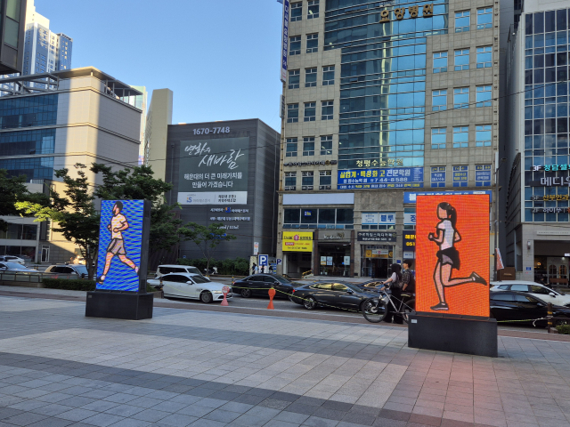 줄리안 오피, 병사와 변호사, 2018년 설치, LED, 높이 각 224×128×28cm, 장소 해운대 더에이치스. 김경진 제공