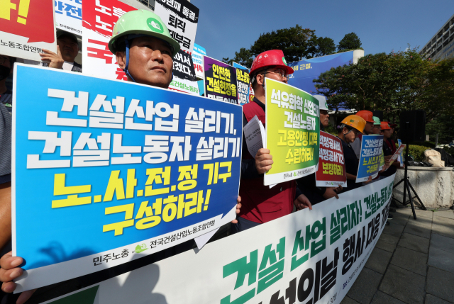 27일 건설의 날 기념식이 열리는 서울 강남구 건설회관 앞에서 건설산업 관련 노조 관계자들이 안전한 건설 현장을 촉구하는 기자회견을 열고 손팻말을 들고 있다. 연합뉴스