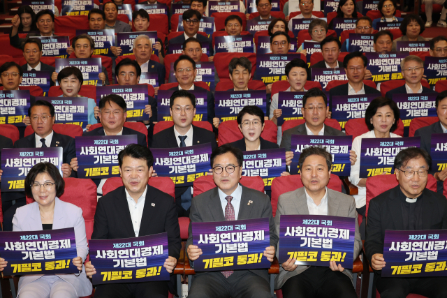 28일 서울 여의도 국회 의원회관에서 열린 더불어민주당 사회연대경제 입법 한마당 및 더불어민주당 입법추진단 발족식에서 우원식 국회의장 등 참석자들이 손팻말을 들고 있다. 연합뉴스