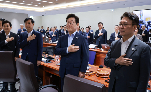 이재명 대통령이 29일 서울 용산 대통령실 청사에서 열린 임시 국무회의에서 국기에 경례하고 있다. 연합뉴스