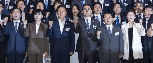 더불어민주당 정청래 대표와 김병기 원내대표를 비롯한 소속 의원들이 지난달 29일 인천시 중구 파라다이스시티 컨벤션에서 열린 2025 정기국회 더불어민주당 의원단 워크숍에서 논의해 확정한 결의문을 낭독한 뒤 구호를 제창하고 있다. 연합뉴스