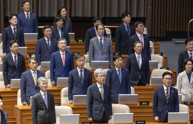 김민석 국무총리(앞줄 오른쪽부터), 김상환 헌법재판소장, 조희대 대법원장과 국무위원들이 1일 국회에서 열린 정기국회 개회식에 참석해 애국가를 부르고 있다. 연합뉴스