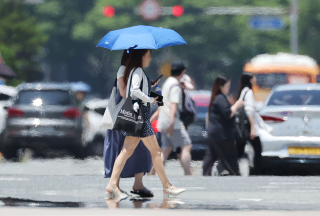 지난달 2일 부산 해운대구 벡스코 인근 도로에서 시민들이 지열로 아지랑이가 피어오르는 횡단보도를 건너고 있다. 정종회 기자 jjh@