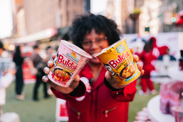삼양식품은 불닭볶음면이 전 세계적인 인기를 얻으며 주가가 3년간 1600% 성장하는 등 고공행진 중이다. 사진은 해외 소비자가 불닭볶음면을 들어보이고 있다. 삼양식품 제공