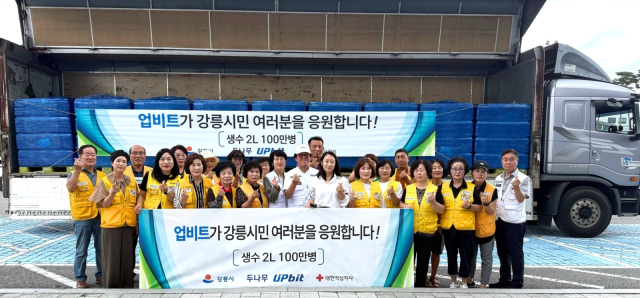 업비트가 강릉시에 생수 100만 병을 기부한 뒤 대한적십자사 강릉지구봉사원 관계자들과 함께 기념 촬영을 하고 있다. 두나무 제공