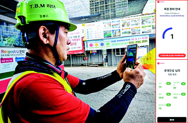 롯데건설 근로자가 스마트폰으로 건강상태 확인 앱을 사용하고 있다. 롯데건설 제공