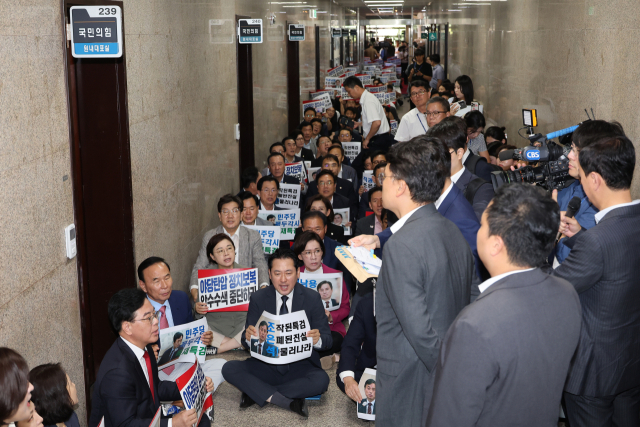 '계엄 해제 표결 방해 의혹'을 수사하는 조은석 내란 특별검사팀의 국민의힘 원내대표실에 대한 압수수색 시도가 이어지고 있는 3일 국민의힘 의원들이 서울 여의도 국회 원내대표실 앞에서 '야당탄압 정치보복 압수수색 중단하라'라고 적힌 손팻말을 들고 농성을 하고 있다. 연합뉴스