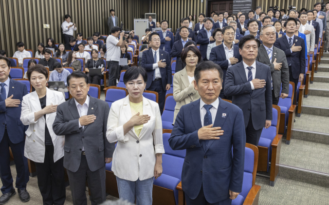 더불어민주당 정청래 대표와 김병기 원내대표를 비롯한 소속 의원들이 3일 국회에서 열린 검찰개혁·정부조직법 개편 의견 수렴을 위해 열린 정책 의원총회에 참석해 국기에 경례하고 있다. 연합뉴스