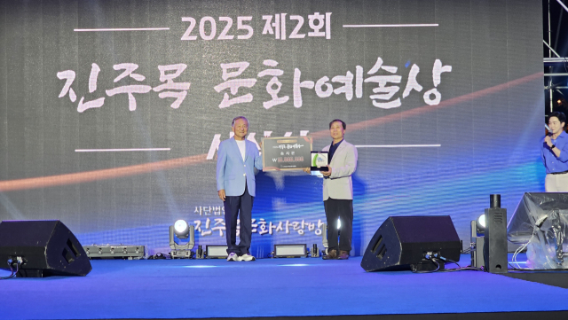 진주목문화사랑방 이상호 회장이 송재원 대리 수상자에게 ‘진주목 문화예술상’을 전달하고 있다. 진주목문화사랑방 제공