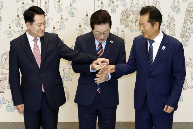이재명 대통령이 8일 용산 대통령실에서 여야 지도부 오찬 회동에 참석한 더불어민주당 정청래 대표, 국민의힘 장동혁 대표와 기념촬영을 위해 손을 잡고 있다. 연합뉴스