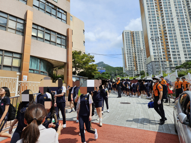 8일 부산 북구 A중학교 학생들이 폭발 테러 예고 사실이 알려진 직후 학교 밖으로 대피하고 있다. 부산소방재난본부 제공