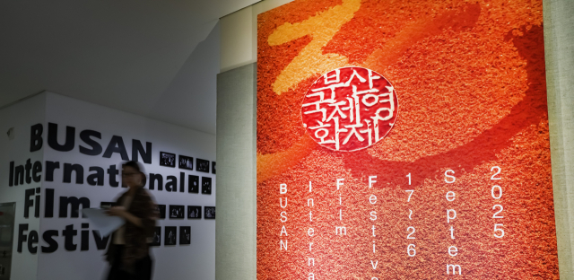제30회 부산국제영화제 개막을 일주일여 앞둔 9일 부산 해운대구 영화의전당에 영화제 공식 포스터 앞으로 관계자가 지나가고 있다. 김종진 기자 kjj1761@