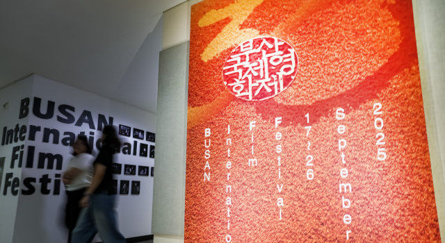 제30회 부산국제영화제 개막을 일주일여 앞둔 9일 부산 해운대구 영화의전당에서 영화제 관계자가 올해 영화제 공식 포스터 앞을 지나가고 있다. 김종진 기자 kjj1761@