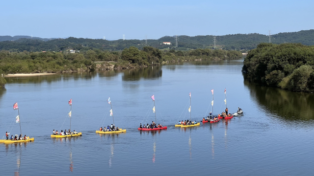 경남 의령군에서 열리는 리치리치페스트벌을 찾은 관광객들이 뱃길 투어를 체험하며 거부 탄생 전설 담긴 경남 솥바위를 구경하고 있다. 의령군 제공