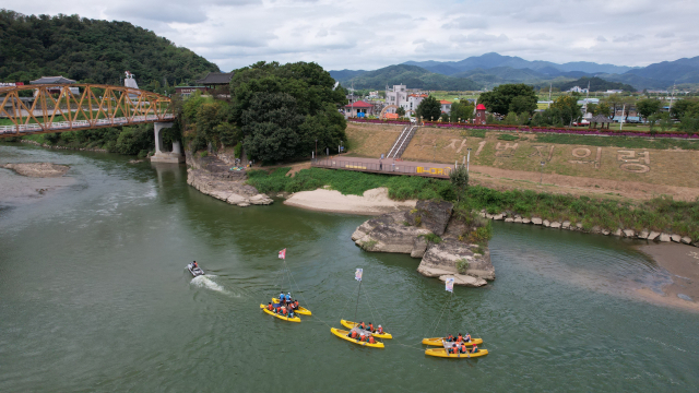 경남 의령군에서 열리는 리치리치페스트벌을 찾은 관광객들이 뱃길 투어를 체험하며 거부 탄생 전설 담긴 경남 솥바위를 구경하고 있다. 의령군 제공