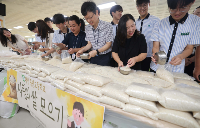 10일 부산 동래구 용인고등학교 학생식당에서 학생과 교직원들이 추석을 앞두고 모은 쌀을 비닐에 담고 있다. 용인고는 이번 행사를 통해 모은 쌀을 동래종합사회복지관에 기부하고, 복지관은 해당 쌀로 송편을 빚어 홀몸노인 등 지역 내 취약계층에 전달할 예정이다. 용인고는 2000년부터 해마다 사랑의 쌀 모으기 운동을 열고 있다. 이재찬 기자 chan@