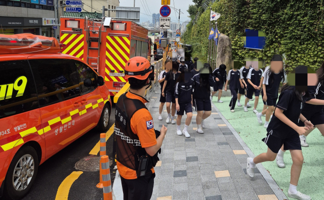지난 8일 부산 북구의 한 중학교 학생들이 폭발 테러 예고 사실이 알려진 직후 학교 밖으로 대피하고 있다. 부산소방재난본부 제공