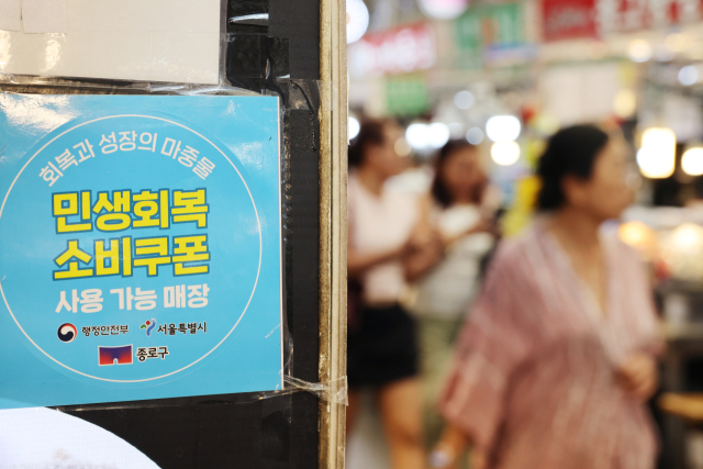 오는 22일부터 전 국민의 90%에 2차 민생회복 소비쿠폰이 1인당 10만 원씩 지급 된다. 사진은 12일 서울 시내의 한 가게에 붙은 민생회복 소비쿠폰 사용처 안내문. 연합뉴스