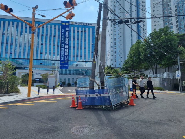 지난 10일 수영경찰서 정문 앞 도로 위에 있던 전봇대 2대를 이설하는 작업이 모두 완료됐다. 사진은 철거 전 전봇대 모습. 부산 수영구청 제공