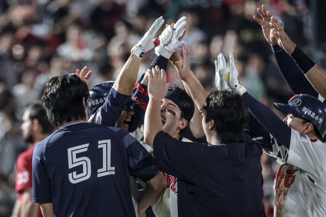 롯데 자이언츠 선수들이 지난 13일 SSG 랜더스전에서 9회말 끝내기 안타를 친 김민성을 둘러싼 채 환호하고 있다. 롯데 자이언츠 제공