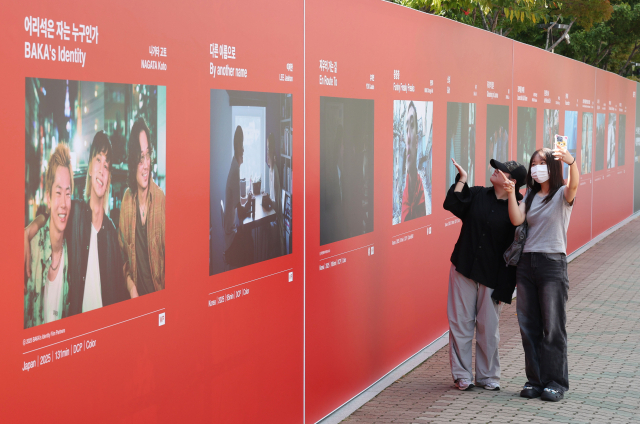 제30회 부산국제영화제 개막을 하루 앞둔 16일 오후 개막식이 열리는 부산 해운대구 영화의전당 앞에서 시민들이 경쟁부문 출품작 포스터를 배경으로 기념사진을 찍고 있다. 올해 영화제는 경쟁부문을 신설, 아시아 주요 작품 14편을 초청해 대상, 감독상, 심사위원 특별상, 배우상, 예술공헌상 등 5개 부분의 부산 어워드를 시상한다. 정종회 기자 jjh@