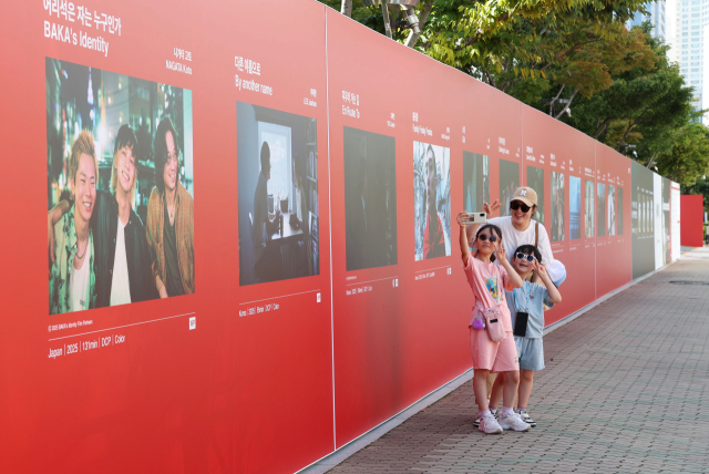 제30회 부산국제영화제 개막을 하루 앞둔 16일 오후 개막식이 열리는 부산 해운대구 영화의전당 앞에서 시민들이 경쟁 부문 출품작 포스터를 배경으로 기념사진을 찍고 있다. 정종회 기자 jjh@