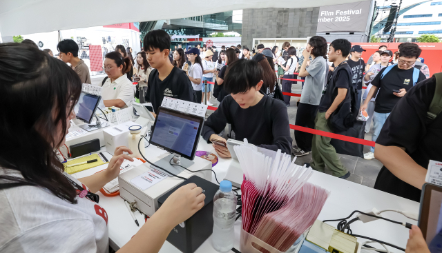제30회 부산국제영화제 개막일인 17일 오전 부산 해운대구 영화의전당을 찾은 영화 팬들이 기념 굿즈를 사기 위해 긴 줄을 서 있다. 김종진 기자 kjj1761@