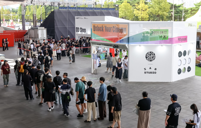 제30회 부산국제영화제 개막일인 17일 오전 부산 해운대구 영화의전당을 찾은 영화 팬들이 기념 굿즈를 사기 위해 긴 줄을 서 있다. 김종진 기자 kjj1761@