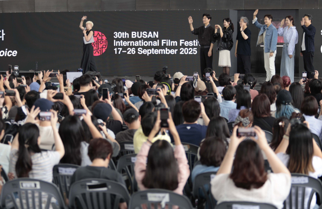 제30회 부산국제영화제 개막 이틀째인 지난 18일 오후 영화의전당 야외무대에서 '어쩔수가없다' 오픈토크가 열렸다. 박찬욱 감독과 배우들이 손을 흔들자 관객들이 일제히 스마트폰을 높이 들어 촬영하고 있다. 이지원 인턴기자