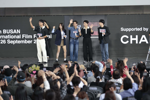 제30회 부산국제영화제 개막 이틀째인 지난 18일 오후 영화의전당 야외무대에서 열린 '보스' 오픈토크에서 배우들이 개봉 일자가 적힌 손팻말을 들고 인사하고 있다. 이지원 인턴기자