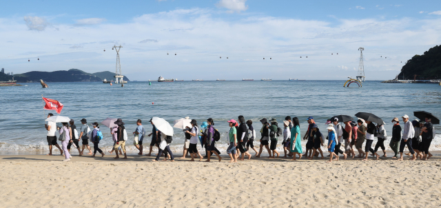 20일 오후 부산 서구 송도해수욕장에서 열린 ‘맨발걷기 좋은 도시 부산 세븐비치 어싱 챌린지’ 행사에서 참가자들이 맨발로 바닷가를 걷고 있다. 이재찬 기자 chan@