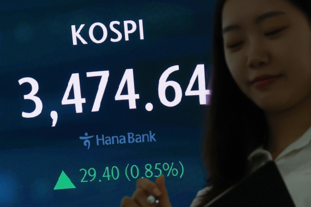 코스피가 22일 삼성전자 강세와 뉴욕 증시의 역대 최고치 행보에 힘입어 장 초반부터 재차 사상 최고치를 경신했다. 22일 서울 중구 하나은행 본점 딜링룸에서 딜러가 업무를 보고 있다. 연합뉴스