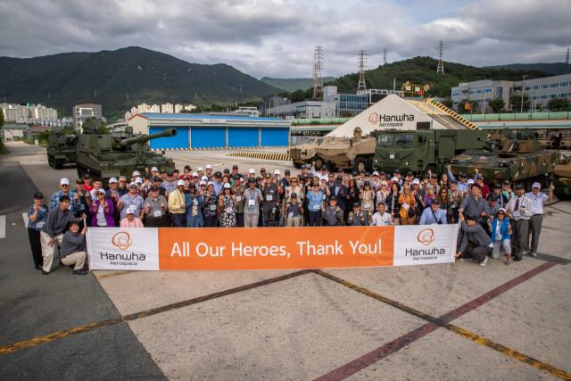 지난 19일 한화에어로스페이스 창원2사업장에서 진행된 ‘참전용사 재방한 행사’에서 6·25전쟁 미국 참전용사 85명 등 관계자들이 주요 무기체계 앞에서 기념촬영하고 있다. 한화에어로스페이스 제공
