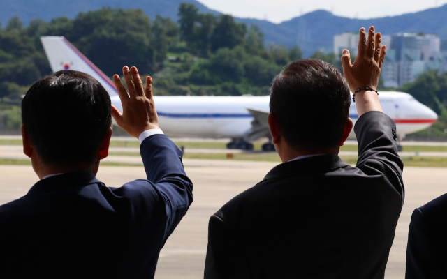 더불어민주당 정청래 대표(왼쪽)와 김병기 원내대표가 22일 성남 서울공항에서 유엔총회 참석차 출국하는 이재명 대통령과 김혜경 여사가 탑승한 공군 1호기를 향해 손을 흔들고 있다. 연합뉴스