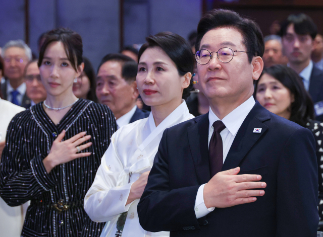 유엔총회 참석차 미국을 방문한 이재명 대통령이 22일(현지시간) 뉴욕의 한 호텔에서 열린 동포간담회에서 참석자들과 함께 국기에 경례하고 있다. 연합뉴스